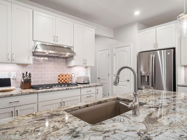 764 Hummingbird Dr, Rochester, MI 48307 - kitchen with stainless steel appliances, under cabinet range hood, a sink, white cabinets, and backsplash