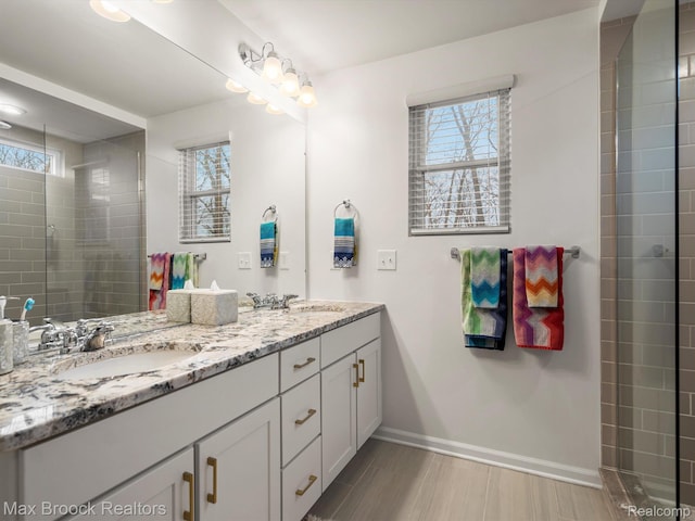 764 Hummingbird Dr, Rochester, MI 48307 - bathroom featuring double vanity, baseboards, and a tile shower