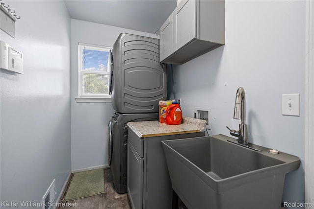 18615 Andrew Ln, New Boston, MI 48164 - laundry room featuring stacked washer / dryer, cabinet space, dark wood finished floors, and baseboards
