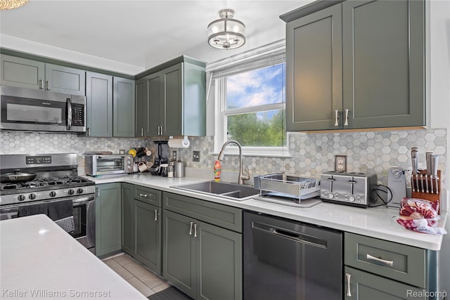 18615 Andrew Ln, New Boston, MI 48164 - kitchen featuring appliances with stainless steel finishes, a sink, light countertops, and backsplash