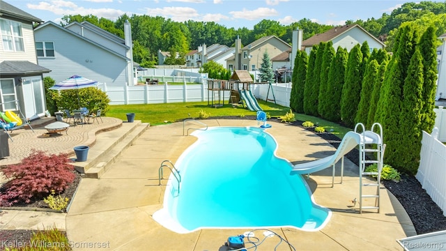 18615 Andrew Ln, New Boston, MI 48164 - view of pool featuring a water slide, a fenced backyard, a playground, and a patio area