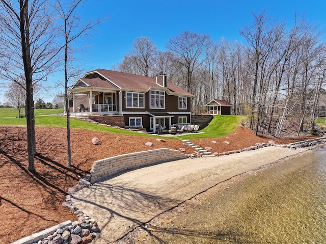 333 S W Silver Lake Rd, Michigan, MI 49685 - view of front facade with a front lawn, covered porch, a patio, and an outdoor structure