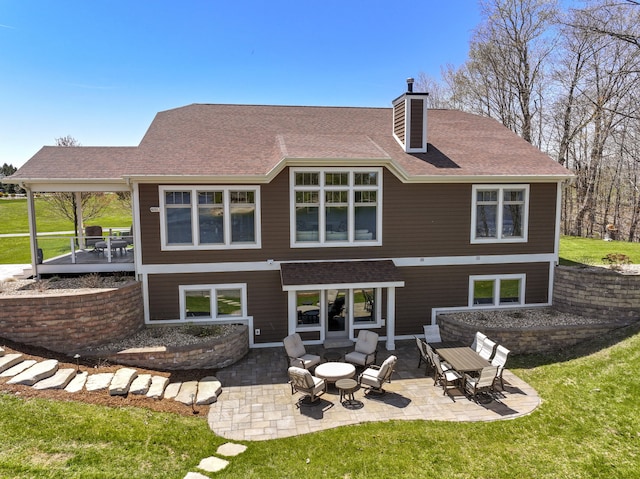 333 S W Silver Lake Rd, Michigan, MI 49685 - back of property with a chimney, a patio, roof with shingles, and a yard
