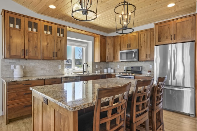 333 S W Silver Lake Rd, Michigan, MI 49685 - kitchen featuring appliances with stainless steel finishes, wood ceiling, light wood-type flooring, brown cabinetry, and a center island