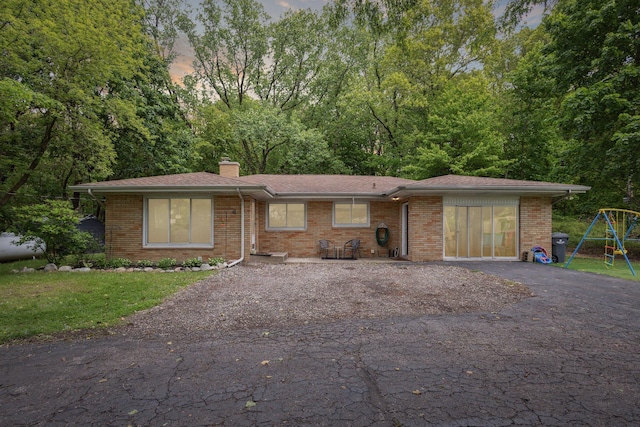 5245 Puetz Rd, Stevensville, MI 49127 - view of front of home featuring a chimney, asphalt driveway, and brick siding