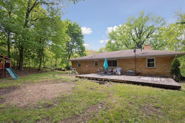 5245 Puetz Rd, Stevensville, MI 49127 - rear view of house featuring a wooden deck, cooling unit, a chimney, brick siding, and a playground