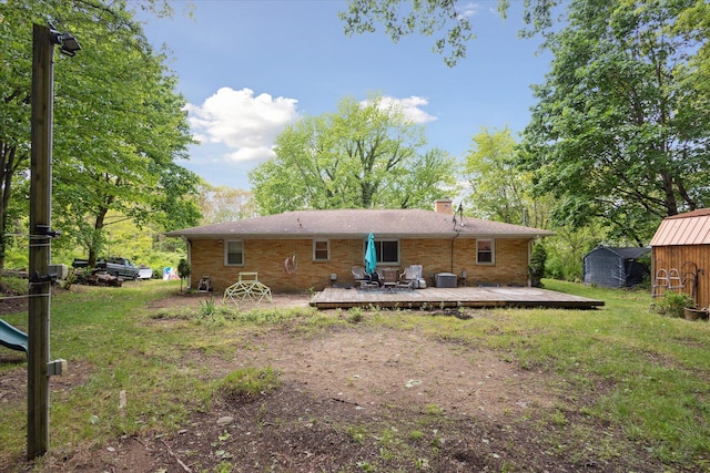 5245 Puetz Rd, Stevensville, MI 49127 - rear view of property with a wooden deck, a chimney, brick siding, central air condition unit, and a yard