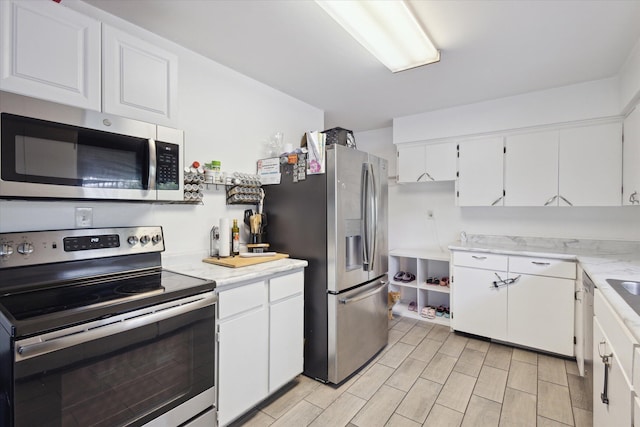 5245 Puetz Rd, Stevensville, MI 49127 - kitchen featuring stainless steel appliances, white cabinetry, and wood finish floors