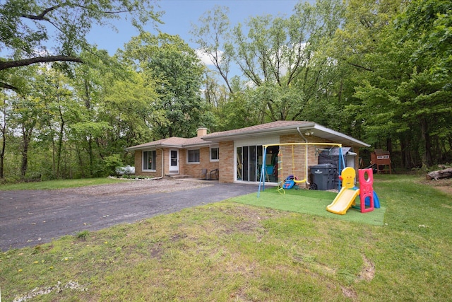 5245 Puetz Rd, Stevensville, MI 49127 - rear view of house with a chimney, a yard, brick siding, and a playground