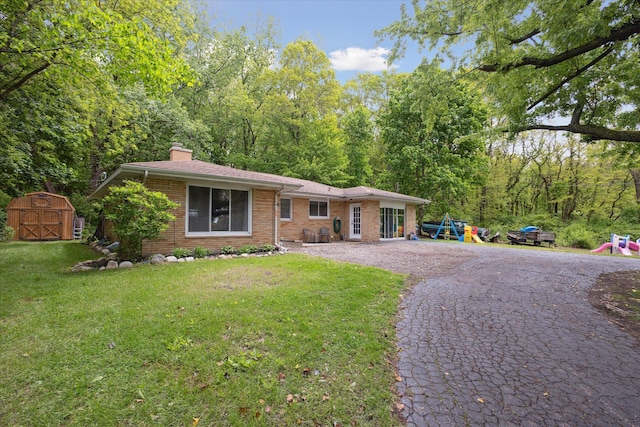 5245 Puetz Rd, Stevensville, MI 49127 - ranch-style house with a playground, brick siding, a chimney, a front yard, and driveway