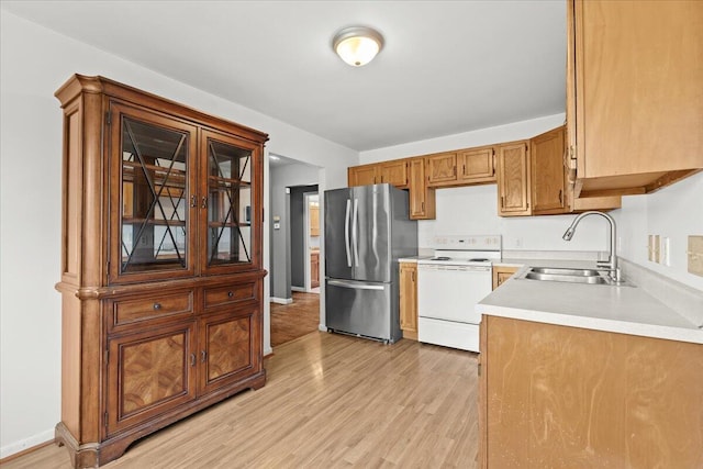 4020 Red Wing Dr, Flint, MI 48532 - kitchen featuring freestanding refrigerator, white range with electric stovetop, a sink, light countertops, and light wood finished floors