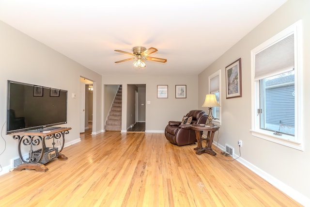 3063 Lansdowne Rd, Waterford, MI 48329 - living area with stairway, a ceiling fan, wood finished floors, and baseboards