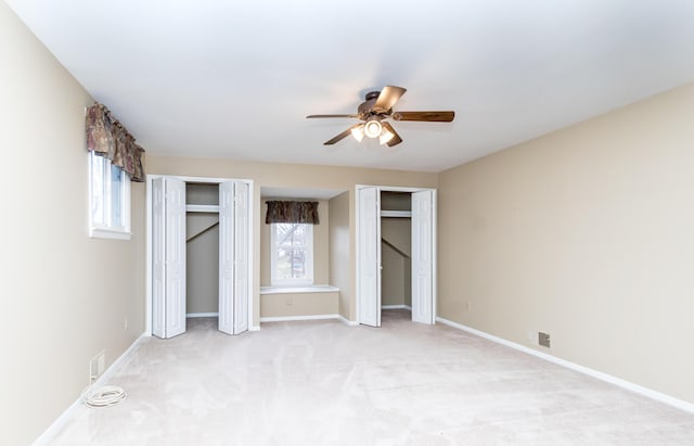 3063 Lansdowne Rd, Waterford, MI 48329 - unfurnished bedroom with two closets, light carpet, baseboards, and ceiling fan