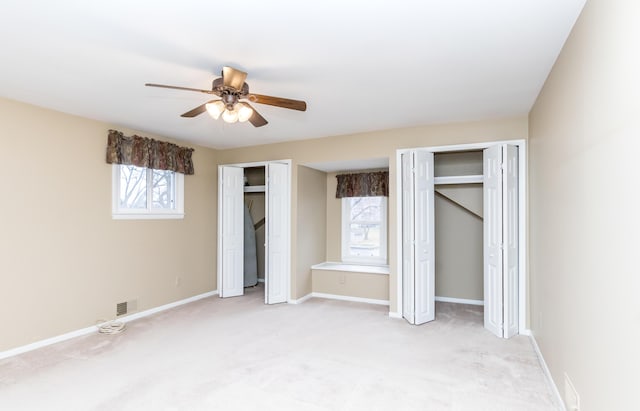3063 Lansdowne Rd, Waterford, MI 48329 - unfurnished bedroom with multiple closets, light carpet, baseboards, and a ceiling fan