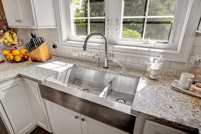 283 Wiley Rd, Douglas, MI 49406 - kitchen featuring a sink, backsplash, healthy amount of natural light, and white cabinets