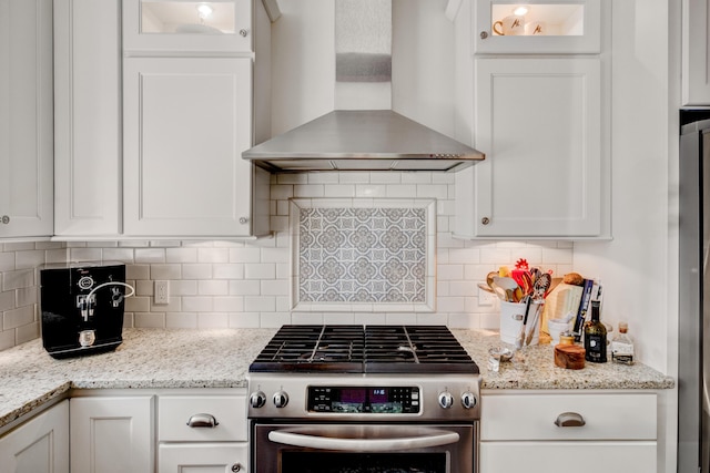 283 Wiley Rd, Douglas, MI 49406 - kitchen with wall chimney range hood, gas stove, and white cabinetry