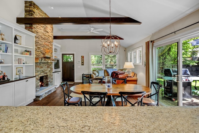 283 Wiley Rd, Douglas, MI 49406 - dining room with dark wood finished floors, healthy amount of natural light, a stone fireplace, and a chandelier