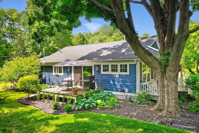 283 Wiley Rd, Douglas, MI 49406 - rear view of house featuring a shingled roof, a lawn, and a deck