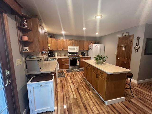 12050 S Ponderosa, Sand Lake, MI 49343 - kitchen with white appliances, a sink, light countertops, light wood-style floors, and recessed lighting