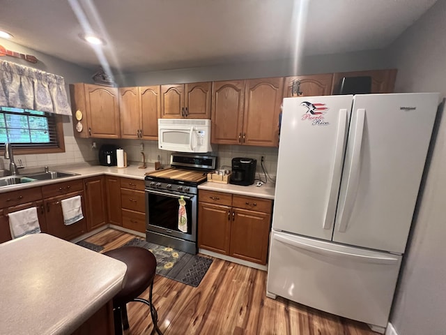 12050 S Ponderosa, Sand Lake, MI 49343 - kitchen featuring white appliances, a sink, decorative backsplash, light wood-type flooring, and light countertops