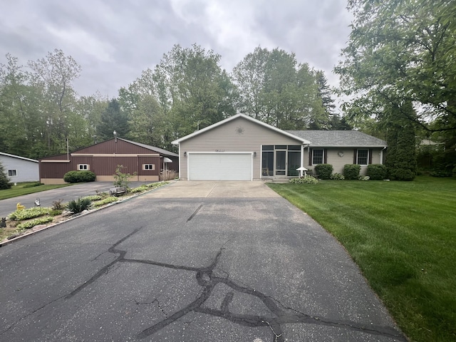 12050 S Ponderosa, Sand Lake, MI 49343 - single story home with asphalt driveway, an attached garage, a front lawn, and view of wooded area