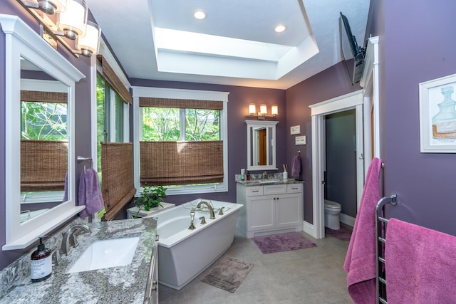10543 Lakeshore Dr, West Olive, MI 49460 - bathroom featuring a freestanding bath, two vanities, toilet, a tray ceiling, and recessed lighting