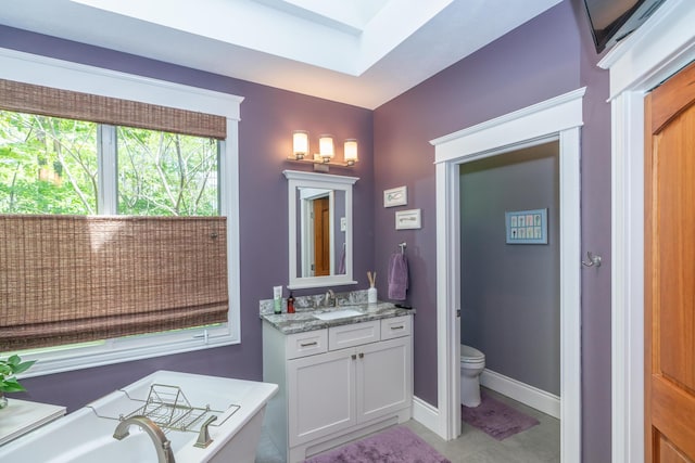10543 Lakeshore Dr, West Olive, MI 49460 - bathroom featuring vanity, a tub, baseboards, toilet, and tile patterned floors