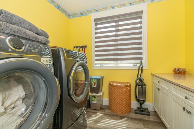10543 Lakeshore Dr, West Olive, MI 49460 - laundry room featuring independent washer and dryer, wood finished floors, cabinet space, and baseboards