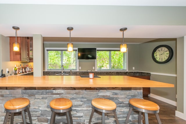 10543 Lakeshore Dr, West Olive, MI 49460 - indoor wet bar with dark wood finished floors, hanging light fixtures, and baseboards