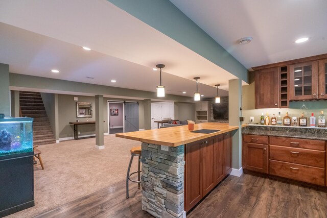 10543 Lakeshore Dr, West Olive, MI 49460 - kitchen with open floor plan, a barn door, a breakfast bar area, glass insert cabinets, and wooden counters