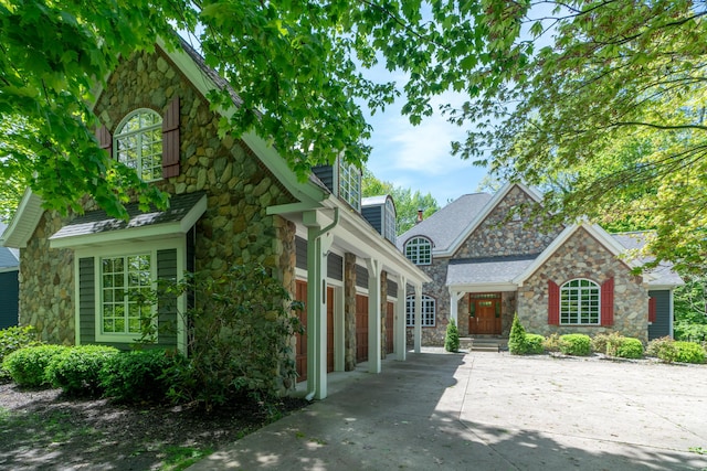 10543 Lakeshore Dr, West Olive, MI 49460 - view of front of property featuring stone siding, concrete driveway, and a garage