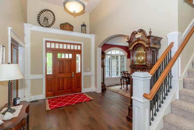 10543 Lakeshore Dr, West Olive, MI 49460 - foyer entrance featuring wood finished floors, arched walkways, a towering ceiling, and stairs
