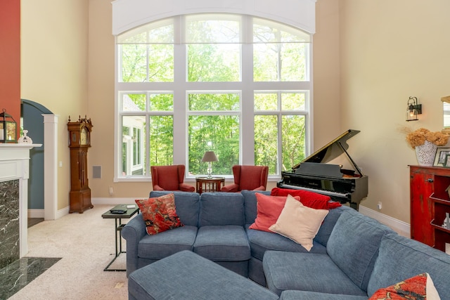 10543 Lakeshore Dr, West Olive, MI 49460 - carpeted living area featuring healthy amount of natural light, a high end fireplace, baseboards, and a high ceiling