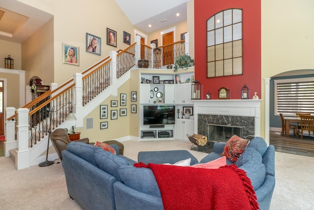 10543 Lakeshore Dr, West Olive, MI 49460 - carpeted living room featuring a towering ceiling, a high end fireplace, stairs, recessed lighting, and baseboards