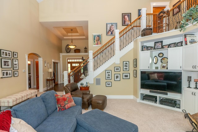 10543 Lakeshore Dr, West Olive, MI 49460 - carpeted living area with a towering ceiling, arched walkways, stairway, and baseboards