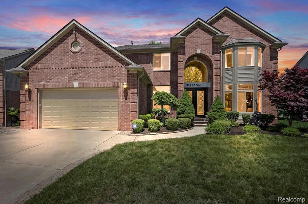 419 Tanner Dr, Troy, MI 48085 - view of front facade featuring brick siding, driveway, an attached garage, and a front lawn