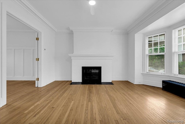 756 Delaware St, Detroit, MI 48202 - unfurnished living room featuring light wood-type flooring, a fireplace, crown molding, and baseboards