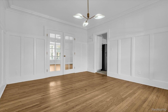756 Delaware St, Detroit, MI 48202 - unfurnished room with a decorative wall, wood finished floors, ornamental molding, french doors, and a chandelier