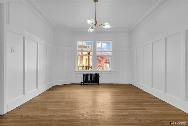 756 Delaware St, Detroit, MI 48202 - unfurnished dining area with a decorative wall, radiator, a chandelier, ornamental molding, and wood finished floors