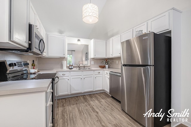 319 Nestlewood Dr Unit 3, Holland, MI 49424 - kitchen with appliances with stainless steel finishes, light countertops, light wood-type flooring, white cabinets, and high vaulted ceiling