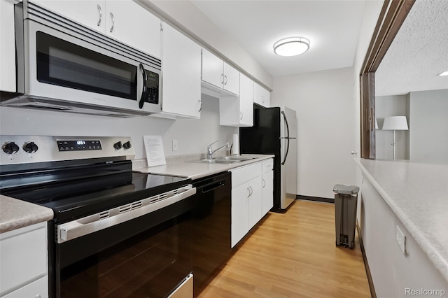 1050 Wall St Unit 8F, Ann Arbor, MI 48105 - kitchen featuring stainless steel appliances, a sink, white cabinetry, and light wood finished floors
