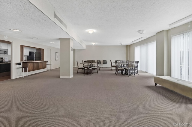 1050 Wall St Unit 8F, Ann Arbor, MI 48105 - dining space featuring carpet, a textured ceiling, and baseboards