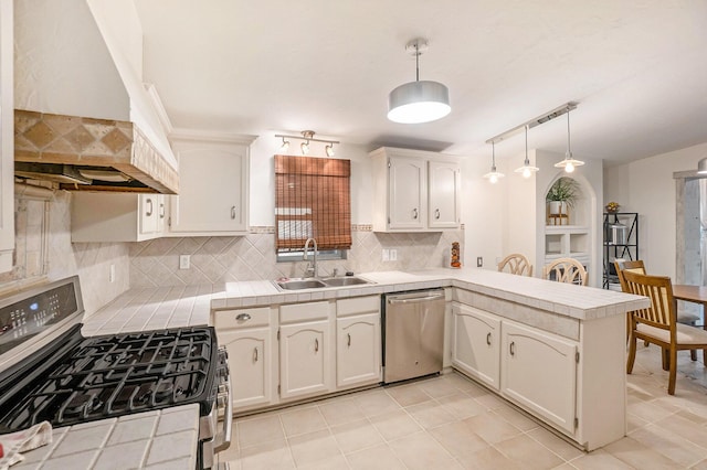 4958 Juniper Rdg, Newaygo, MI 49337 - kitchen with appliances with stainless steel finishes, a sink, wall chimney range hood, a peninsula, and tile countertops