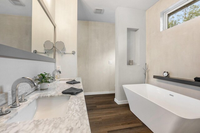 4958 Juniper Rdg, Newaygo, MI 49337 - full bath featuring wood finished floors, a freestanding bath, double vanity, and baseboards