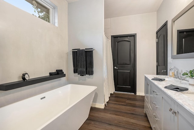 4958 Juniper Rdg, Newaygo, MI 49337 - bathroom with a soaking tub, double vanity, wood finished floors, and baseboards