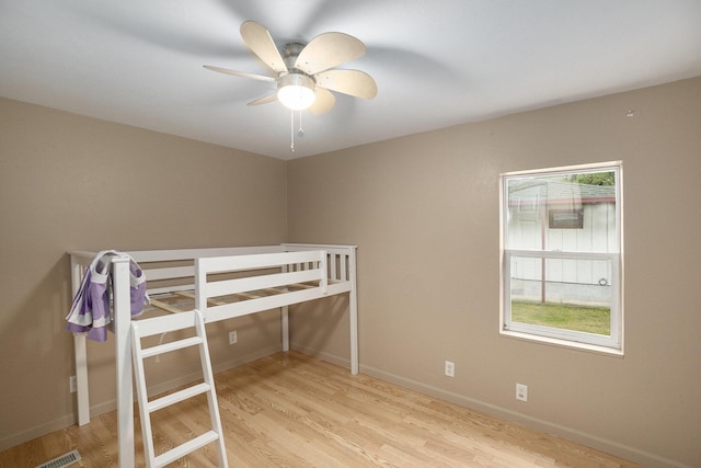 4958 Juniper Rdg, Newaygo, MI 49337 - unfurnished bedroom with wood finished floors, baseboards, and a ceiling fan