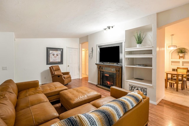 4958 Juniper Rdg, Newaygo, MI 49337 - living room with a warm lit fireplace, wood finished floors, arched walkways, and built in features