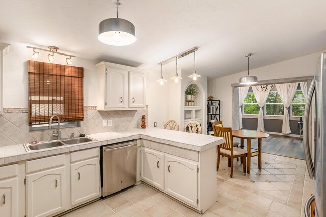 4958 Juniper Rdg, Newaygo, MI 49337 - kitchen featuring stainless steel appliances, a sink, a peninsula, tasteful backsplash, and white cabinetry