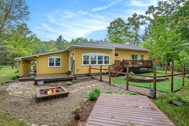 4958 Juniper Rdg, Newaygo, MI 49337 - rear view of house with a fire pit, stucco siding, a wooden deck, a yard, and a patio area