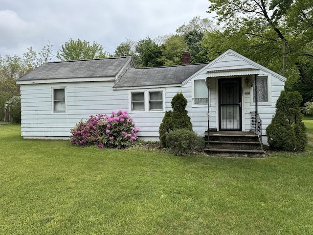 407 Hill St, Buchanan, MI 49107 - view of front of home with roof with shingles, a front lawn, and a chimney